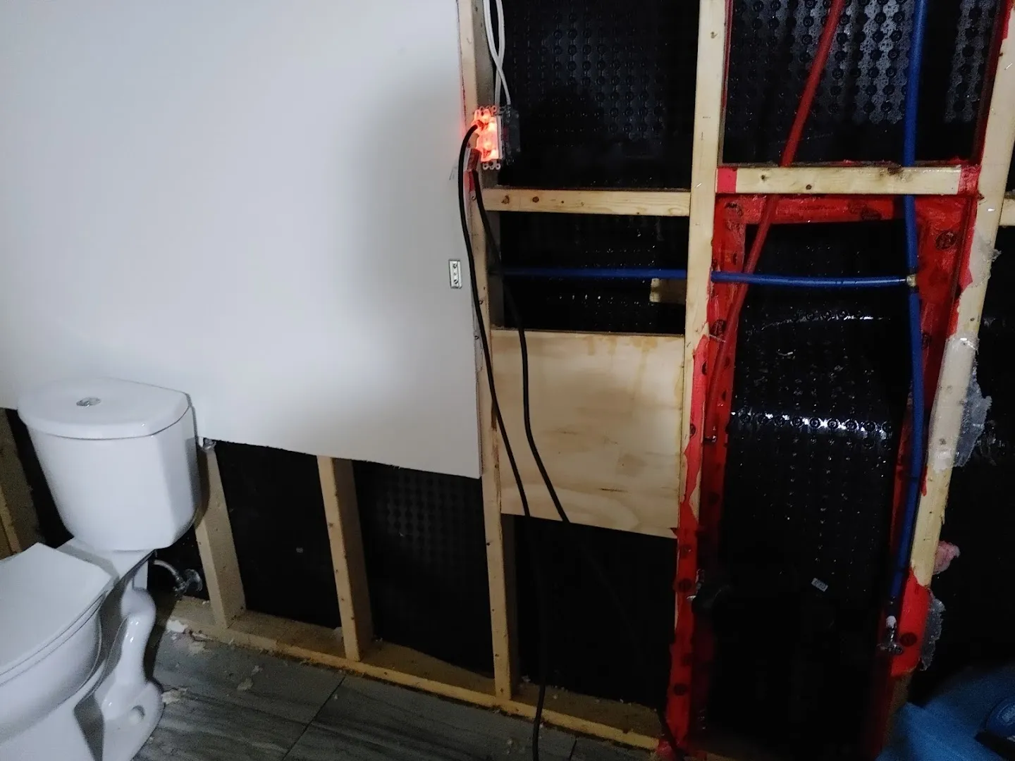 Basement reconstruction area with moisture remediation materials, containment framework and temporary wall systems