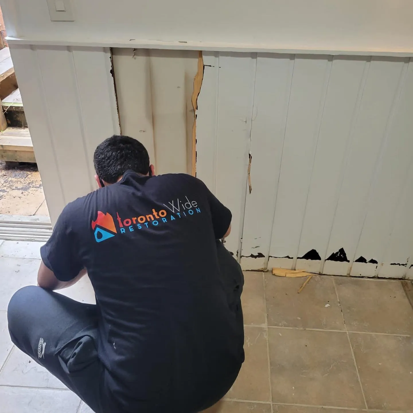 Flooded basement interior with standing water and water removal equipment staging area